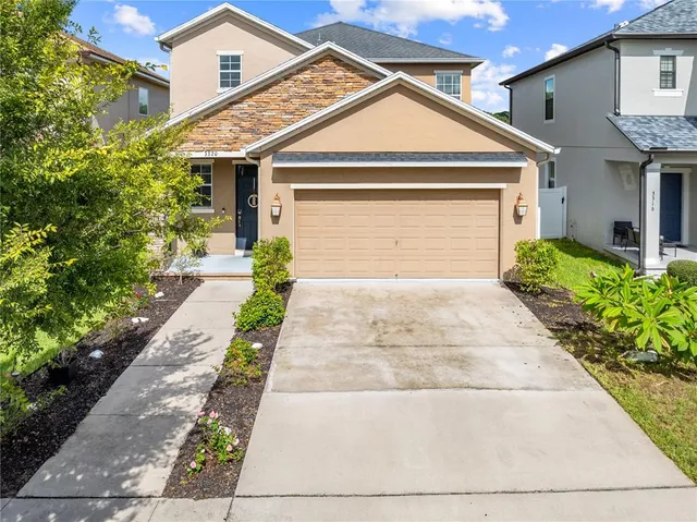 a front view of a house with a yard and a garage