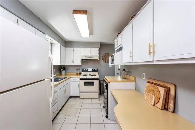 a kitchen with stainless steel appliances granite countertop a stove a sink and white cabinets