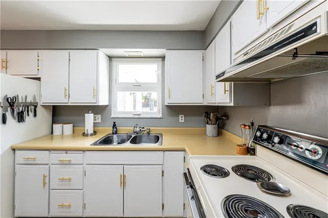a kitchen with a sink a stove and cabinets