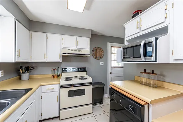 a kitchen with stainless steel appliances white cabinets and a stove top oven