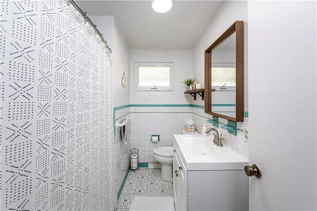 a bathroom with a sink and mirror with toilet