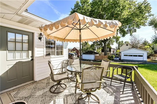 a view of a patio with table and chairs under an umbrella