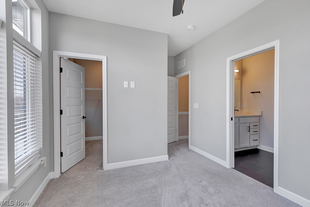 3601 Bailey Avenue Cleveland, OH 44113 - Photo 18 of 22 Unfurnished bedroom with a closet, light carpet, ensuite bathroom, and a walk in closet