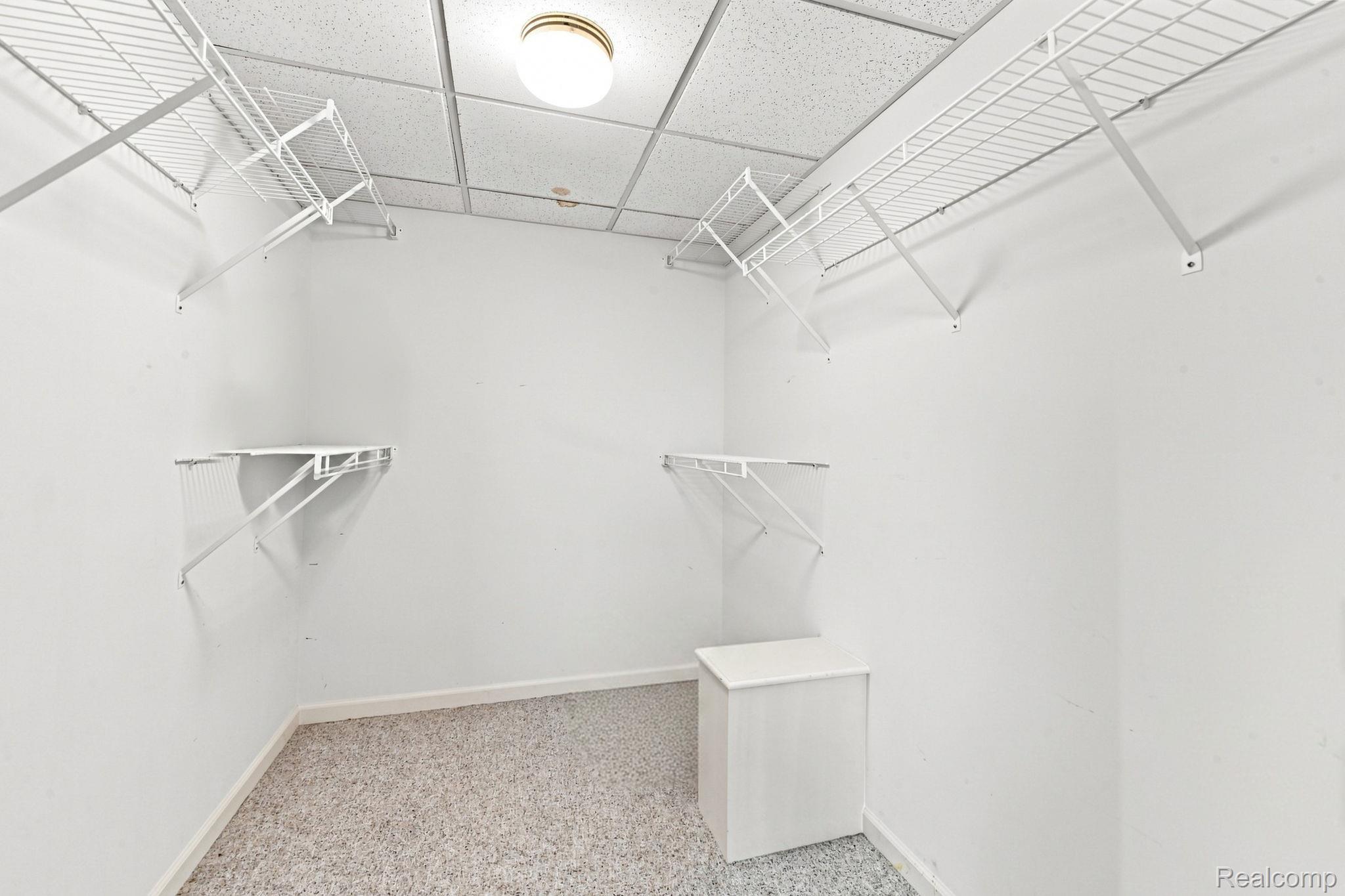 493 Harvard Drive Romeo, MI 48065 - Photo 26 of 36 White wire shelving system with hanging rods, built-in storage cabinet, recessed light fixture, and drop ceiling