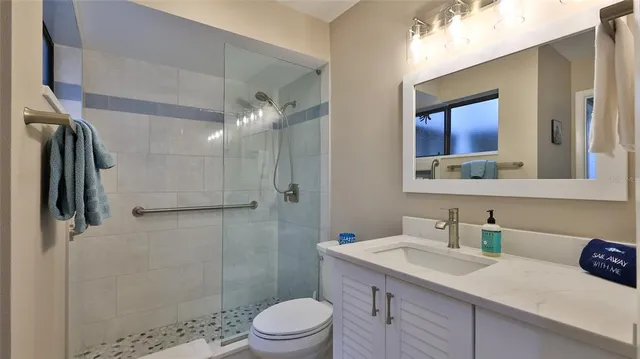 a bathroom with a sink a toilet and shower