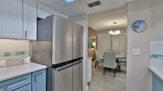 a kitchen with stainless steel appliances a refrigerator and a wooden floor