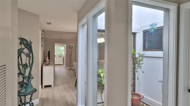 a view of a hallway with wooden floor and entryway