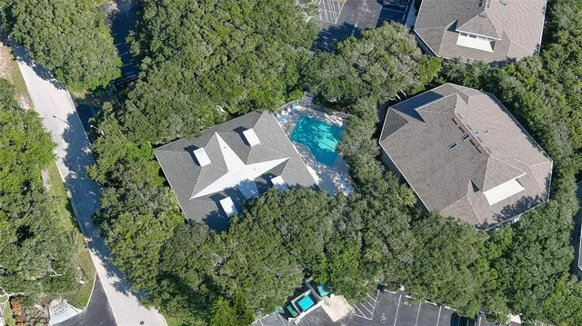 an aerial view of a house with a yard and trees