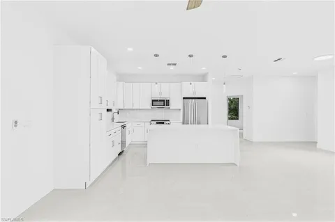 a white kitchen with cabinets and a refrigerator
