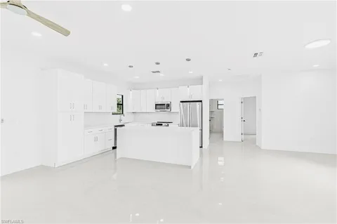 a view of a kitchen with refrigerator and white cabinets