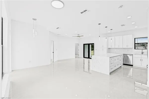 a large white kitchen with white cabinets and white appliances