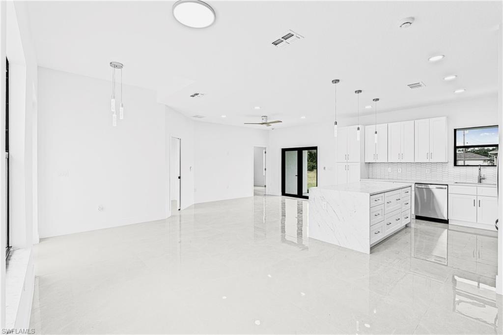 343 Pullman Street Lehigh Acres, FL 33974 - Photo 19 of 48 a large white kitchen with white cabinets and white appliances