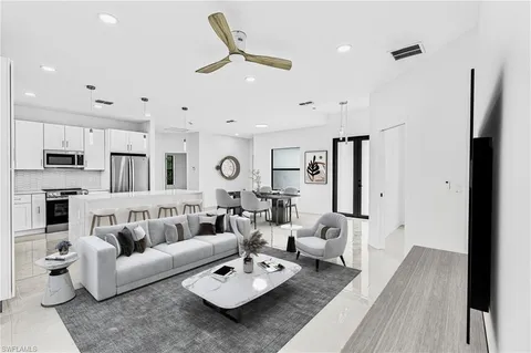 a living room with furniture kitchen view and a wooden floor
