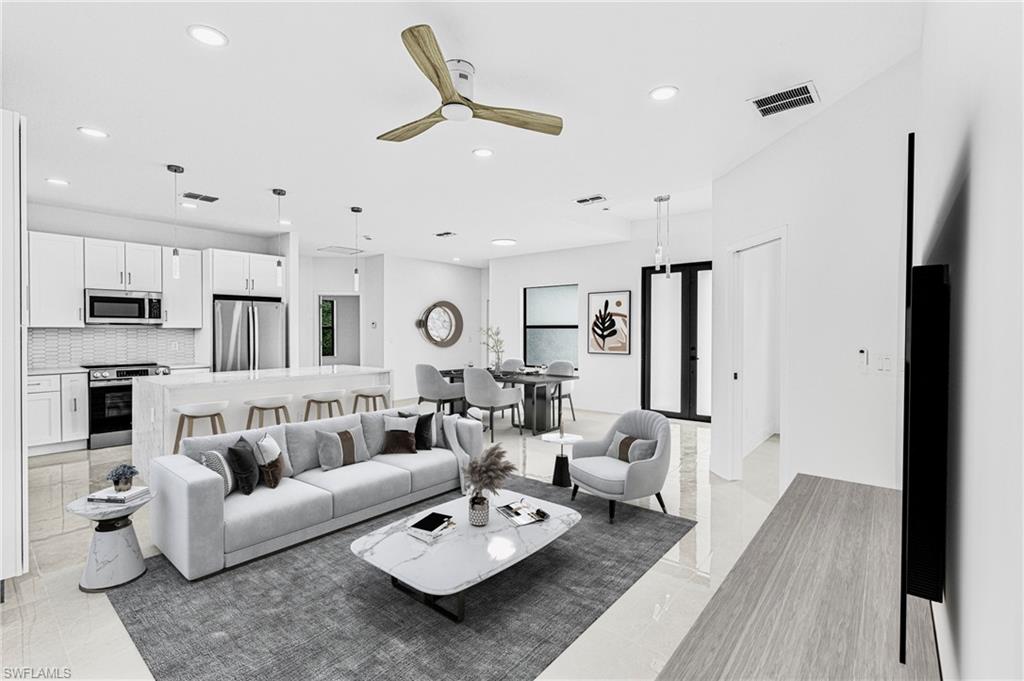 343 Pullman Street Lehigh Acres, FL 33974 - Photo 2 of 48 a living room with furniture kitchen view and a wooden floor