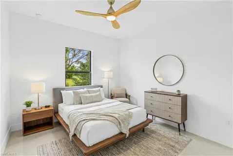 a bedroom with a bed a mirror and a window