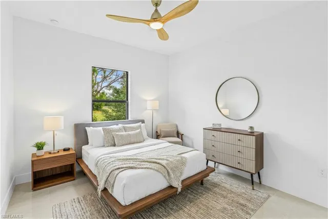 a bedroom with a bed a mirror and a window