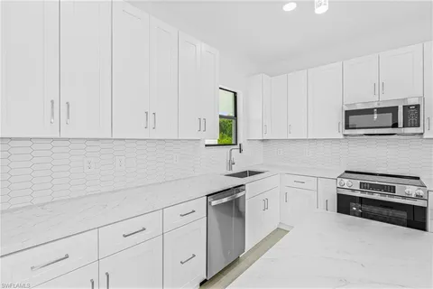 a kitchen with white cabinets and white appliances