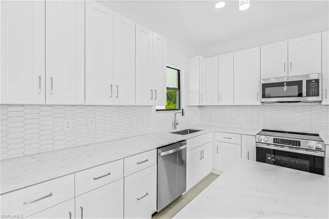 a kitchen with white cabinets and white appliances
