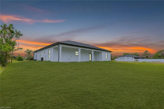 an aerial view of residential houses with outdoor space and trees