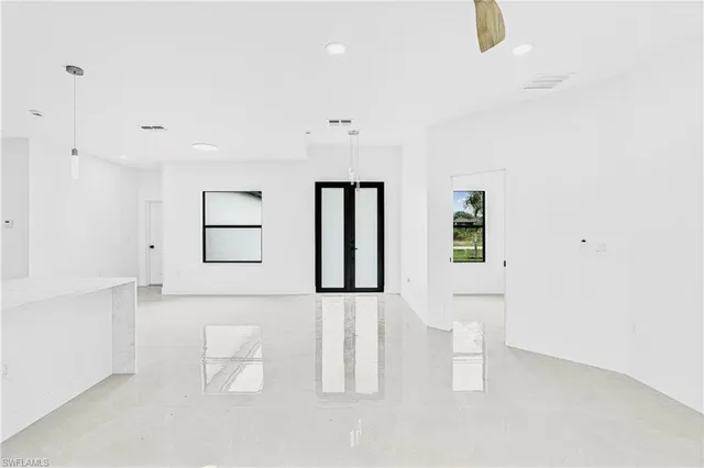 a large white room with a white cabinet and mirror