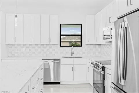 a kitchen with stainless steel appliances a refrigerator sink and cabinets