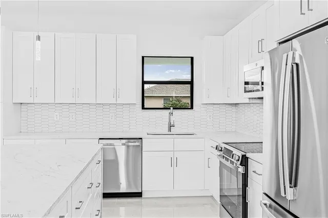 a kitchen with stainless steel appliances a refrigerator sink and cabinets