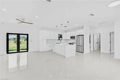 a large white kitchen with white cabinets and refrigerator