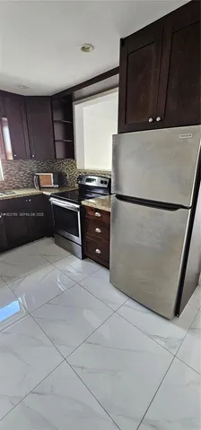 a kitchen with granite countertop a refrigerator and a stove