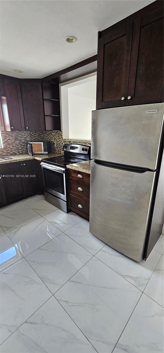 7775 Southwest 86th Street, Unit F1301 Miami, FL 33143 - Photo 13 of 20 a kitchen with granite countertop a refrigerator and a stove
