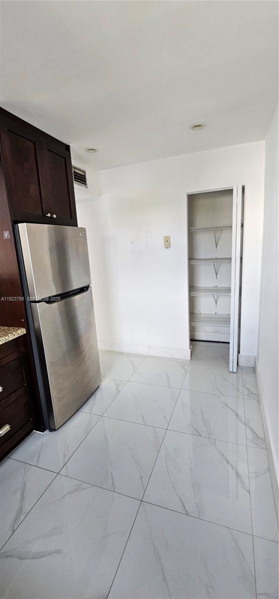 7775 Southwest 86th Street, Unit F1301 Miami, FL 33143 - Photo 15 of 20 a view of a refrigerator in kitchen and an empty room