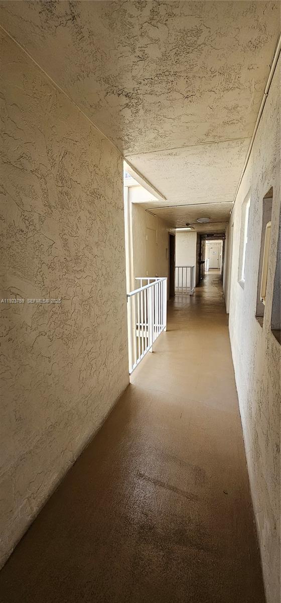 7775 Southwest 86th Street, Unit F1301 Miami, FL 33143 - Photo 6 of 20 a view of a hallway with wooden floor and a bathroom
