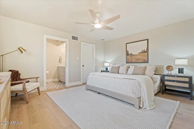 a spacious bedroom with a bed and a chandelier