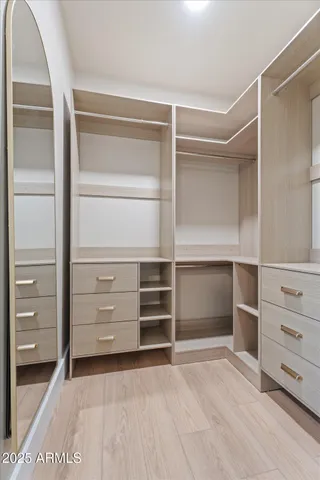a room with walk in closet and white cabinet