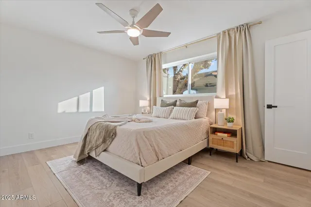 a bedroom with a bed and a painting on the wall