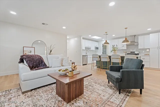 a living room with furniture kitchen view and a table