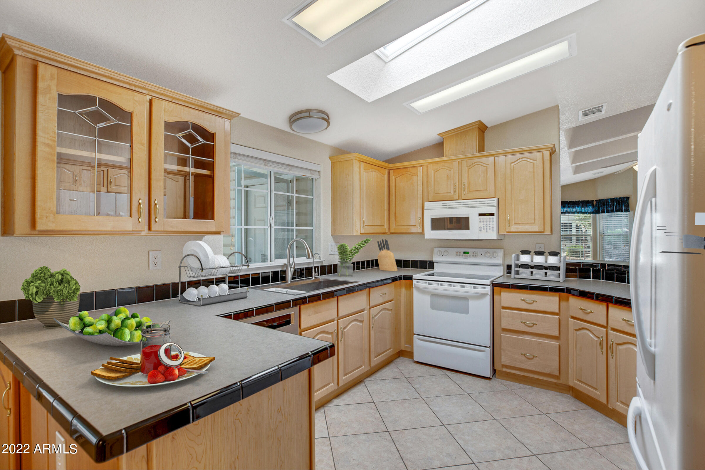 3301 South Goldfield Road, Unit 4083 Apache Junction, AZ 85119 - Photo 3 of 12 a kitchen with a stove a sink a dining table and chairs