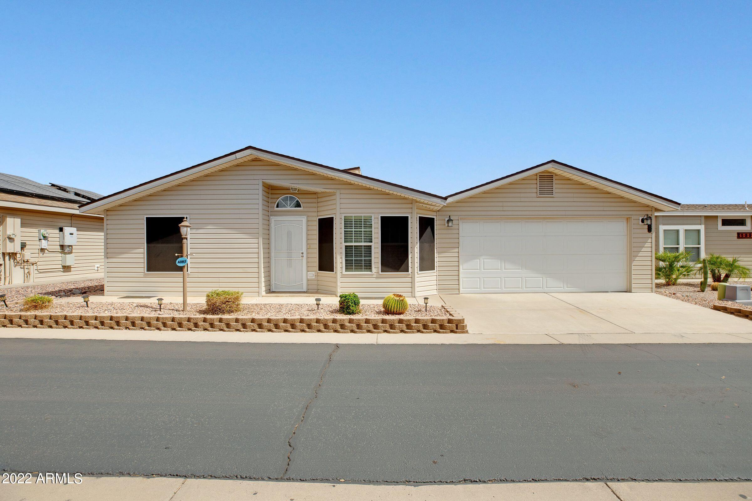 3301 South Goldfield Road, Unit 4083 Apache Junction, AZ 85119 - Photo 4 of 12 a front view of a house with a garden