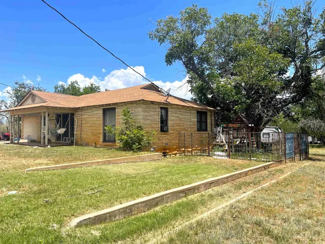 a view of a house with a backyard and a tree
