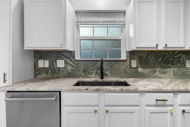 a kitchen with granite countertop a refrigerator sink and cabinets