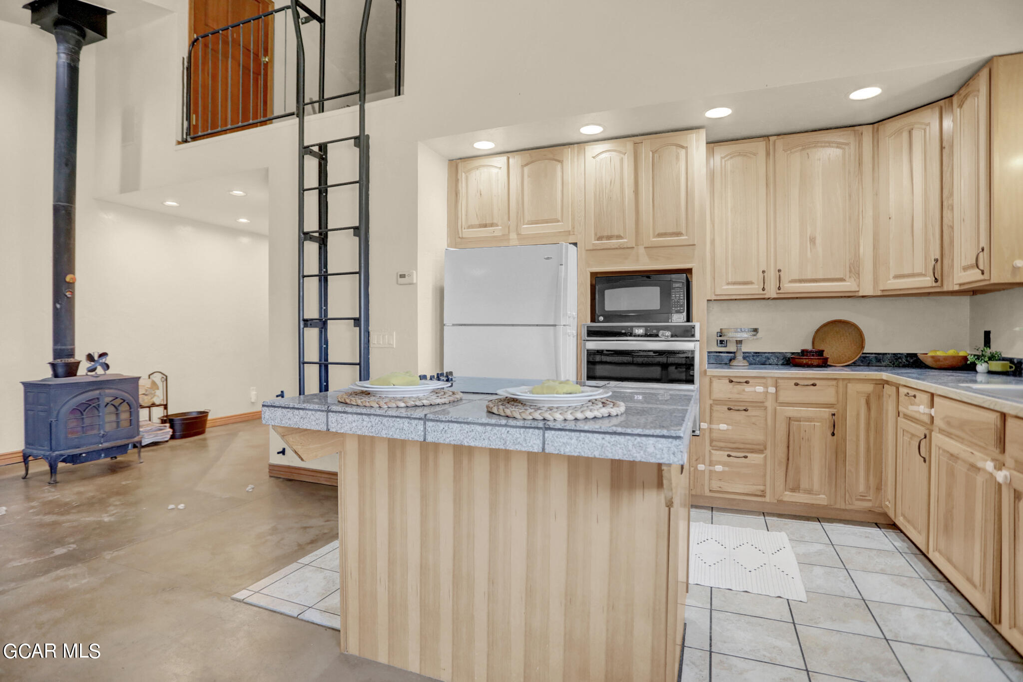 91 3rd Avenue Parshall, CO 80468 - Photo 2 of 48 a kitchen with kitchen island granite countertop wooden cabinets and white appliances