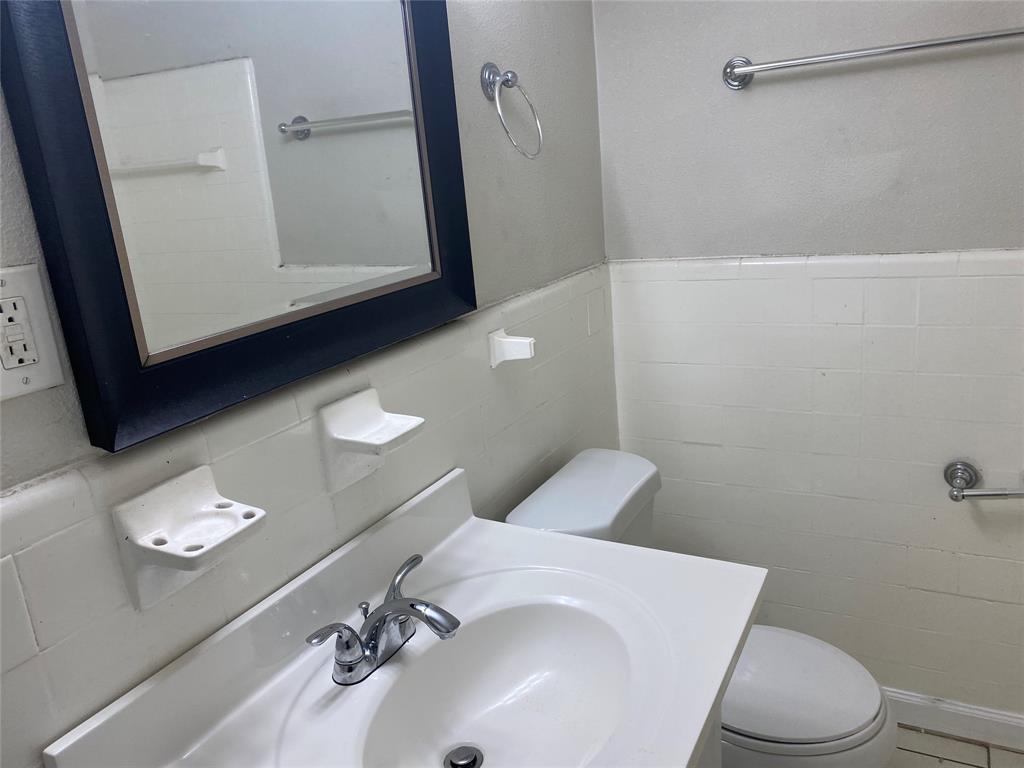 4618 Reiger Avenue, Unit 112 Dallas, TX 75246 - Photo 11 of 13 Hallway with dark wood-style flooring and a textured wall