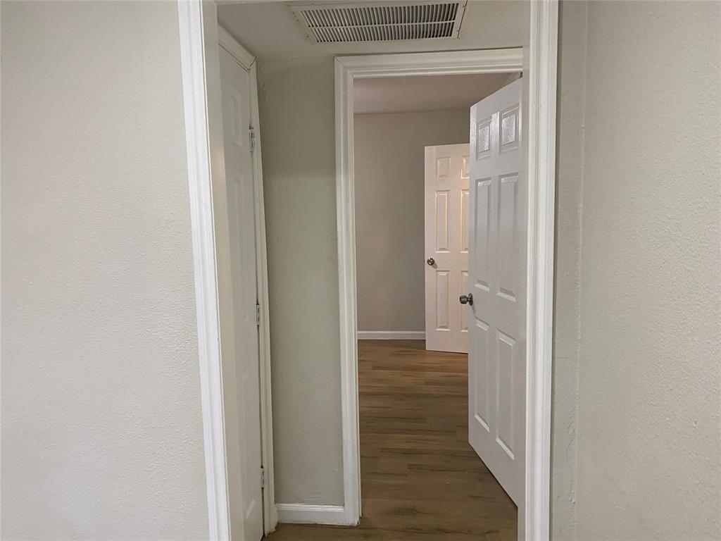 4618 Reiger Avenue, Unit 112 Dallas, TX 75246 - Photo 10 of 13 Hallway with dark wood-style flooring and a textured wall