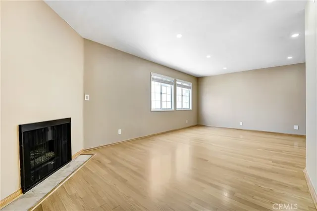 a view of an empty room with a fireplace and a window