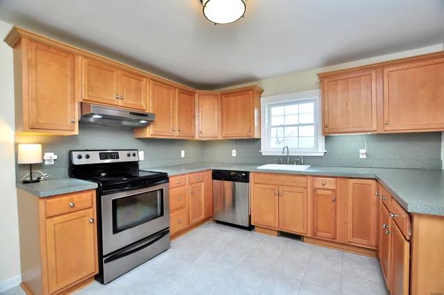 a kitchen with stainless steel appliances granite countertop sink stove and granite counter top