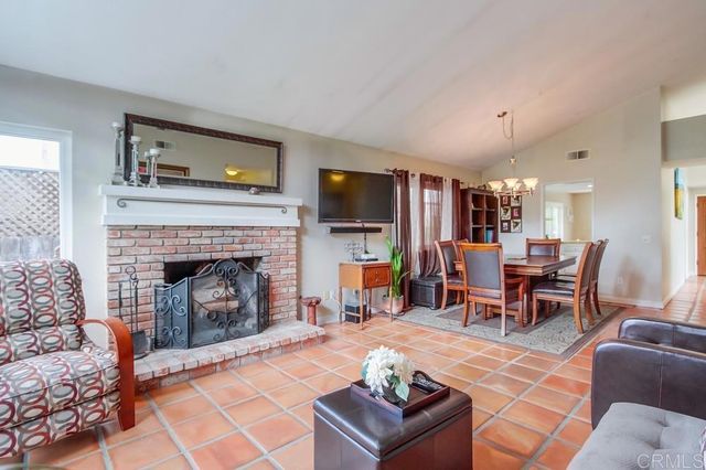 a living room with furniture a flat screen tv and kitchen view