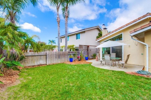 a view of a swimming pool with a yard and potted plants