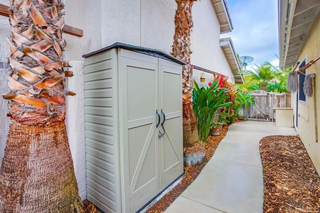 a view of a patio with table and chairs potted plants and floor to ceiling window and potted plants