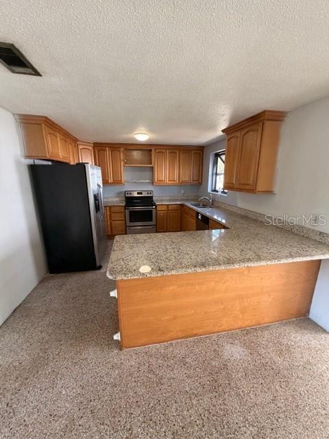 1701 Raleigh Avenue Daytona Beach, FL 32117 - Photo 10 of 16 a kitchen with granite countertop a refrigerator and a stove top oven