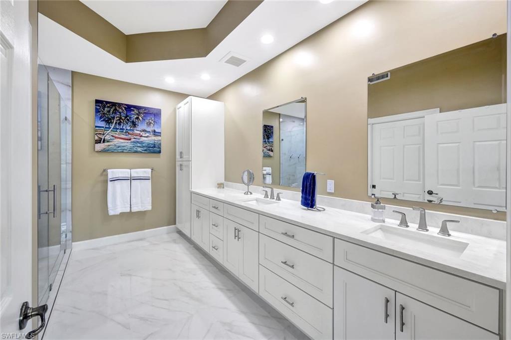 9193 Quartz Lane, Unit 102 Naples, FL 34120 - Photo 22 of 50 a spacious bathroom with double sink and a mirror