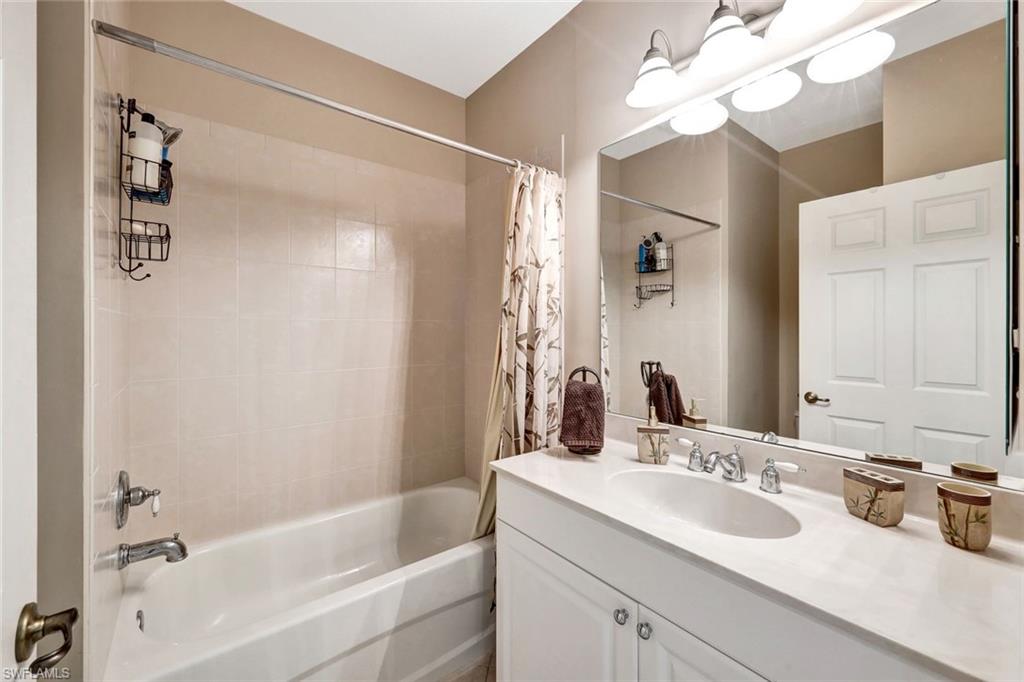 9193 Quartz Lane, Unit 102 Naples, FL 34120 - Photo 25 of 50 a bathroom with a sink a mirror and a bathtub with a mirror